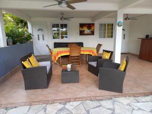 a patio with a table and chairs on a patio at COQUET F2 CLIMATISE AVEC PISCINE AU LAMENTIN in Le Lamentin