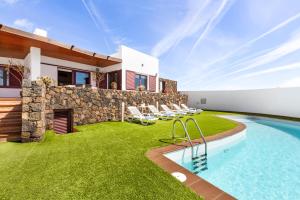 un cortile con piscina e una casa di Home2Book Luxury Villa Playa Honda, Private Pool a Playa Honda
