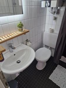 a bathroom with a white toilet and a sink at Juna in Laboe
