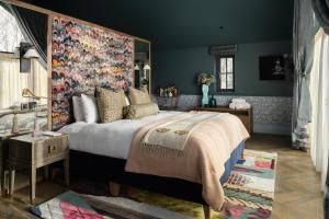 a bedroom with a large bed with a floral headboard at The Tempus at Charlton Hall Estate in Alnwick