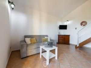 ein Wohnzimmer mit einem Sofa und einem Tisch in der Unterkunft Sun & Sea Studio in Tortolì