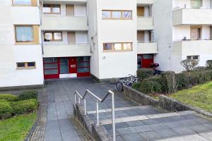 a building with red doors and a sign in front of it at 2-room apartment with balcony in Meckenheim