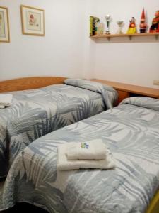 Dos camas en una habitación con toallas. en LA CASA DE SENSI en Güéjar-Sierra