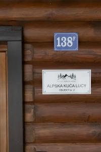 Jasenak的住宿－Alpska kuća Lucy，木结构一侧的标志