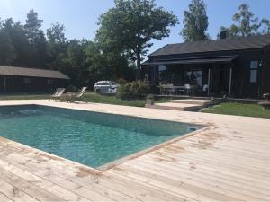 a swimming pool in front of a house at Unique house with Saltwater pool on Gotland in Romakloster