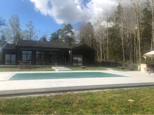 une maison avec une piscine en face de celle-ci dans l'établissement Unique house with Saltwater pool on Gotland, à Romakloster