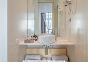a white bathroom with a sink and a mirror at Gòtic by The 5ve Soul in Barcelona