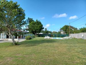 a park with white picnic tables and a tree at La villa Rouyo in Le Moule