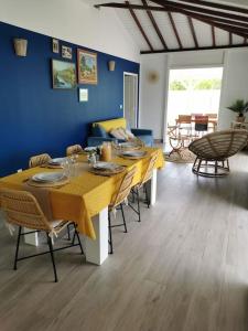 a dining room with a yellow table and chairs at La villa Rouyo in Le Moule
