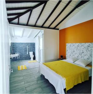a bedroom with a large bed and a bathroom at La villa Rouyo in Le Moule