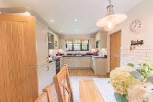 una cucina con tavolo e orologio sul muro di Roseberry Cottage Coniston a Coniston