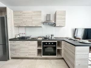 a kitchen with wooden cabinets and a black counter top at Cosy one bedroom Apartment 3 by Solea in San Ġwann