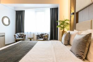 a bedroom with a large bed with a large window at Unique Boutique in Bucharest