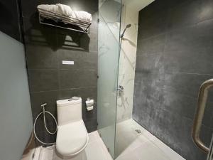 a bathroom with a toilet and a glass shower at The UpperRoom @ Real Suites in Bacolod