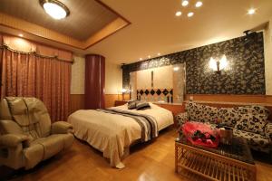 1 dormitorio con 1 cama, 1 silla y 1 sofá en Hotel La Siesta (Adult Only), en Kioto