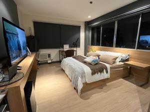 um quarto com uma cama grande e uma televisão de ecrã plano em The UpperRoom @ Real Suites em Bacolod