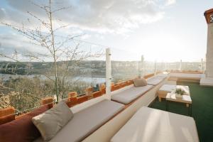 een balkon met banken en uitzicht op het water bij AltoCanto in Coimbra