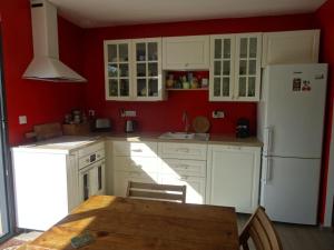 een keuken met witte kasten, een tafel en een koelkast bij Beau 2 pièces avec jardin dans villa à Mougins. in Mougins