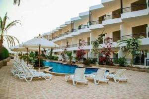 un hotel con una piscina con sillas y sombrillas en studio inside resort including private sand beach en Hurghada