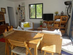 een woonkamer met een tafel en een bank bij Beau 2 pièces avec jardin dans villa à Mougins. in Mougins