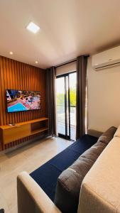 a hotel room with a bed and a flat screen tv at "Perto do Mar", Aconchego no Coração da Vila! in Porto De Galinhas