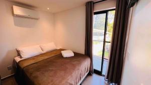 a bedroom with a bed with a large window at "Perto do Mar", Aconchego no Coração da Vila! in Porto De Galinhas +23 photos