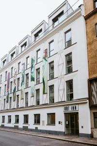 a white building with flags on the side of it at ART-INN Design Self-Check-in-Hotel in Linz