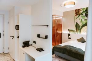 ein Schlafzimmer mit einem Bett und einem Schreibtisch in einem Zimmer in der Unterkunft ART-INN Design Self-Check-in-Hotel in Linz