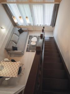 an attic room with stairs and a table and chairs at Hőforrás Hotel in Gyula