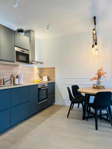 uma cozinha com armários azuis e uma mesa e cadeiras em Apt Ljupka - Zadar - with private free parking em Zadar