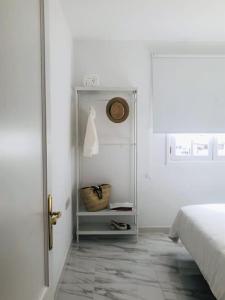 a white bedroom with a bed and a white door at Casa Nicolás in Playa Honda