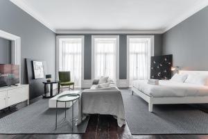 Un dormitorio con una cama, un sofá y un televisor. en GuestReady - Innvict Residences, en Oporto