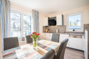 a kitchen with a table with a vase of flowers on it at Kehrwieder Zinnowitz in Zinnowitz