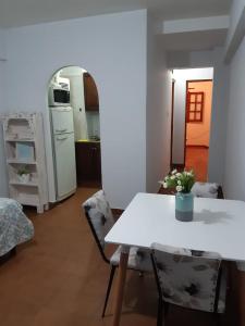 cocina y comedor con mesa blanca y sillas en Departamento Centro en San Salvador de Jujuy
