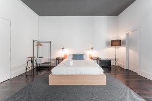 a bedroom with a bed and a table with two lamps at GuestReady - Astern Innvict - Street view in Porto