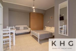 a bedroom with two beds and a table and chairs at SEA VIEW RETREAT STUDIO IN AGIOS KONSTANTINOS! in Dhavgáta