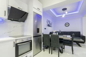 una cucina e una sala da pranzo con tavolo e sedie di Jensila Suite by "elite" a Città di Zante Altre 17 foto