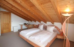 Cama en habitación con techo de madera en Alpenflair Ferienwohnungen Whg 404 en Oberstdorf