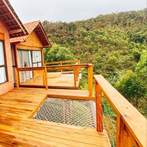 a wooden deck with a view of a mountain at Vila Italliana Chalés - Chalé Milão in Santa Teresa