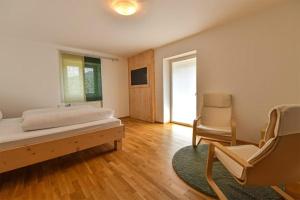 a bedroom with a bed and a chair and a window at GÄSTEHAUS HARTL - Gasthof Hartl, vlg Zum Wirt in Neuhaus