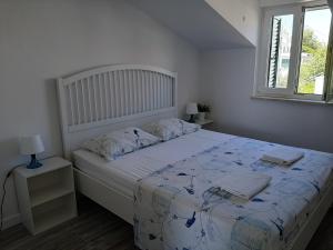 um quarto com uma cama grande e uma colcha branca em Apartment Bruna em Stomorska