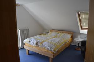 1 dormitorio con 1 cama con edredón amarillo y blanco en Ferienwohnung Schöneck, en Tettnang