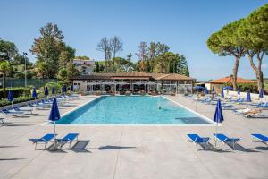 une grande piscine avec chaises et parasols dans l'établissement Il Pelagone Hotel & Golf Resort Toscana, à Gavorrano