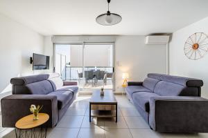 ein Wohnzimmer mit 2 Sofas und einem TV in der Unterkunft Moderne, piscine, parking privé, climatisation, 3 chambres in Six-Fours-les-Plages