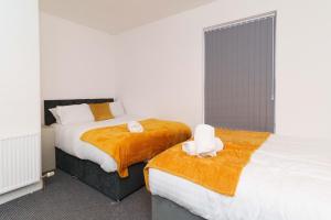 sypialnia z 2 łóżkami i ręcznikami w obiekcie Dent House Stays w mieście Hunslet