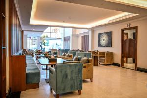 a lobby with couches and tables and chairs at sas blue suites in Jeddah
