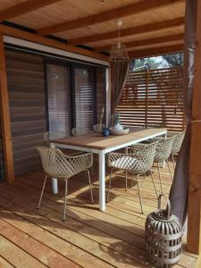 einen Tisch und Stühle auf einer Holzterrasse in der Unterkunft Eliška Holiday Home in Biograd na Moru