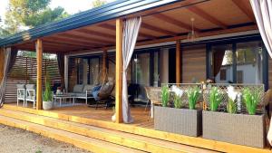 ein Haus mit einer Holzterrasse mit Pflanzen in der Unterkunft Eliška Holiday Home in Biograd na Moru