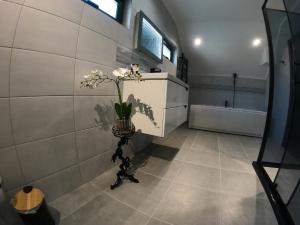 a bathroom with a vase of flowers on the wall at Villa Serenity in Balchik +55 photos
