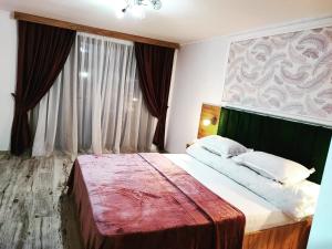 een slaapkamer met een groot bed en een groot raam bij Casa de vacanta Estera Rucar in Rucăr +15 foto's